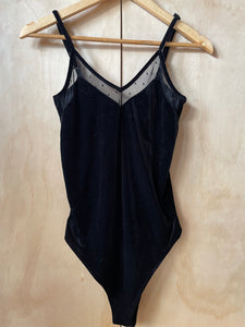 Front of black velvet body suit on hanger